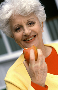 Smiling old Woman Eating Apple, Albuquerque, NM dental implants